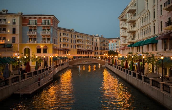 Qanat Quartier at The Pearl-Qatar looks straight out of a European postcard. The pastel-colored buildings, warm lights reflecting on the water, and cozy streets give it a relaxed, charming vibe.